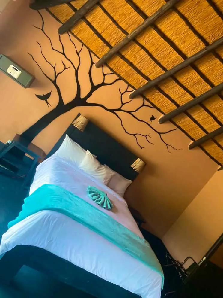 Chalet bedroom with African tree mural headboard